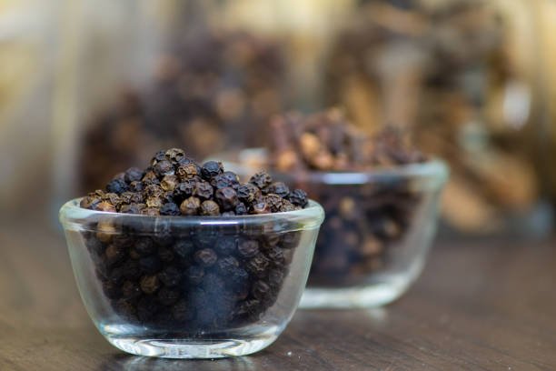 View of Black Peppercorns in a bowl. Black pepper boost immunity naturally. Selective focus.